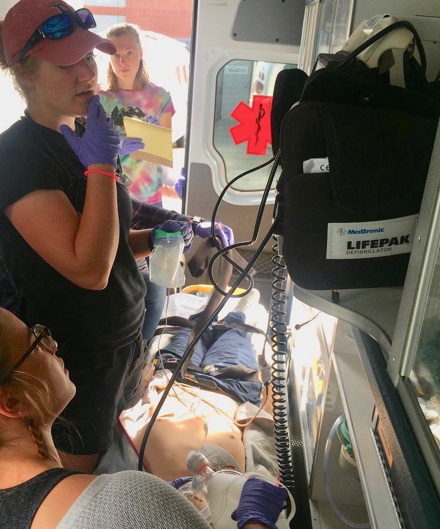 Practicing EMT skills in the back of the ambulance with a mannequin.